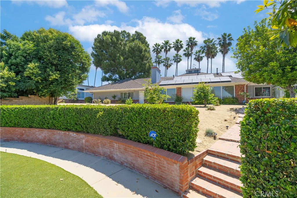 a front view of a house with a yard and potted plants