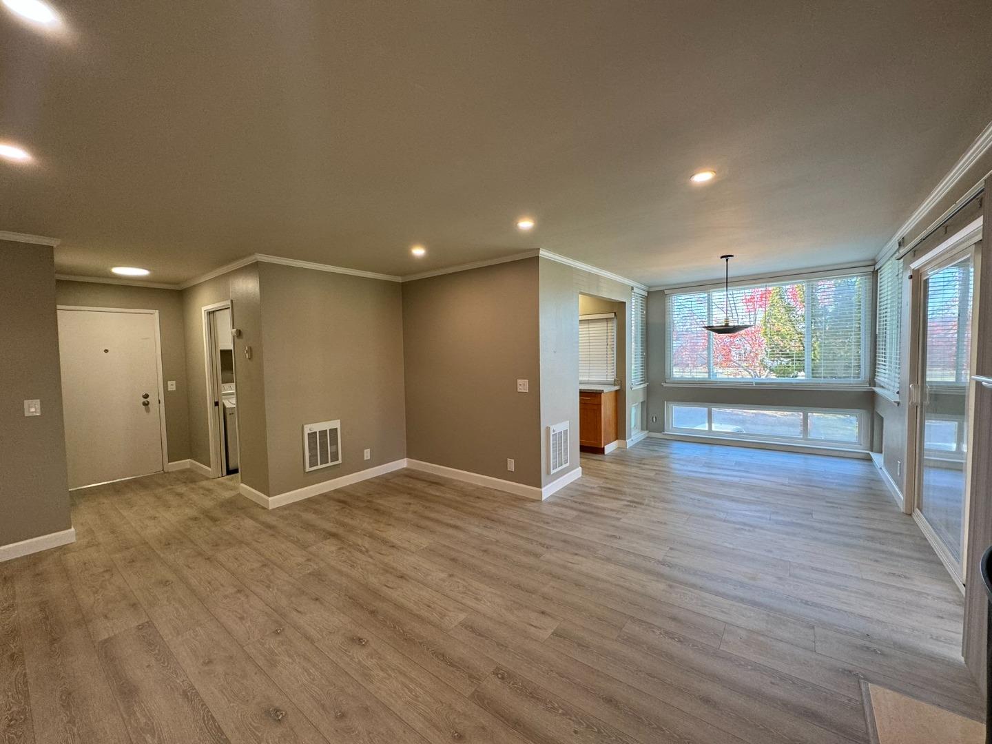 a view of an empty room with wooden floor