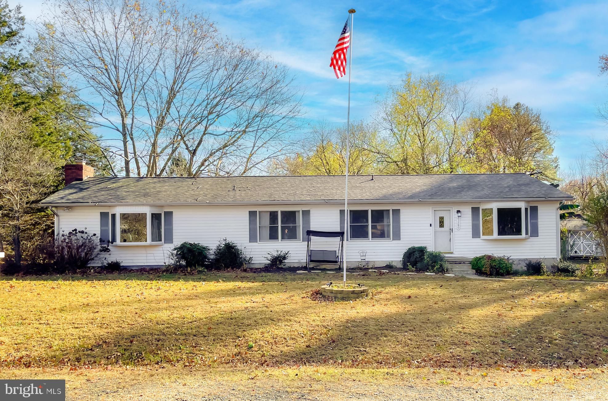 a front view of house with yard and trees around