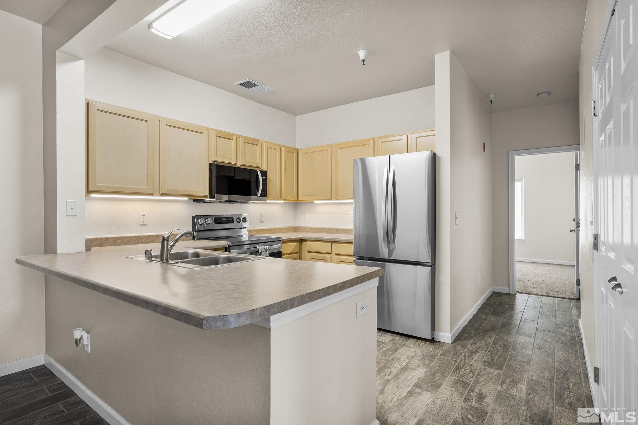 a kitchen with stainless steel appliances a refrigerator stove microwave and sink