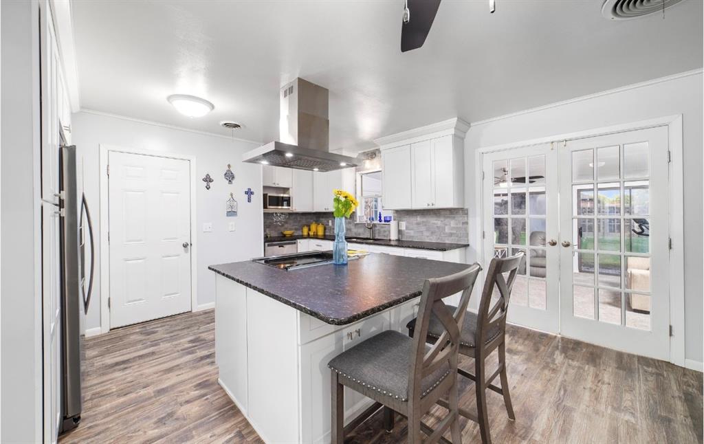 a kitchen with stainless steel appliances granite countertop a sink a stove and a refrigerator