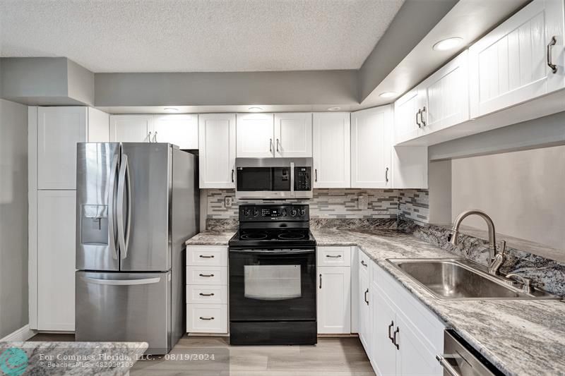 a kitchen with refrigerator a stove and a sink