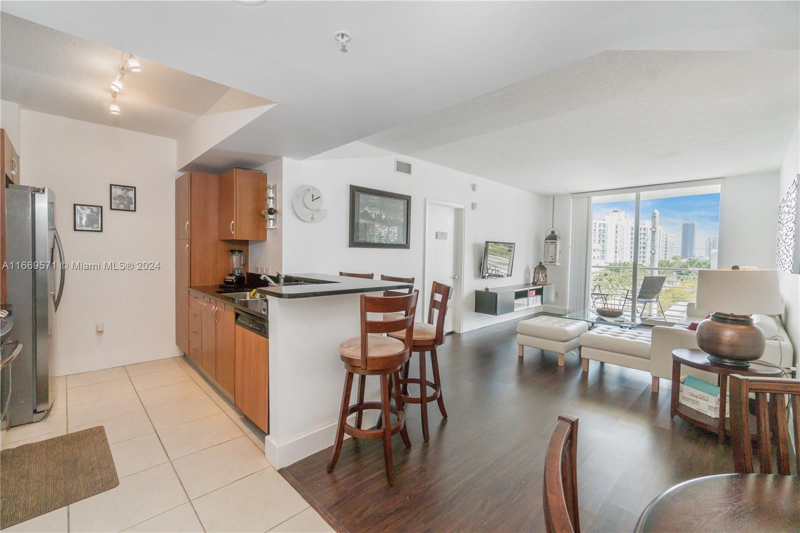 a living room with furniture a flat screen tv and a large window