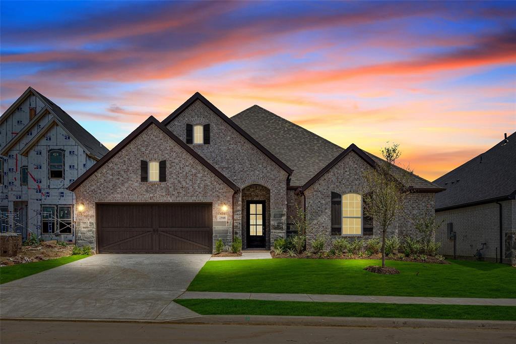 a front view of a house with a garden and yard