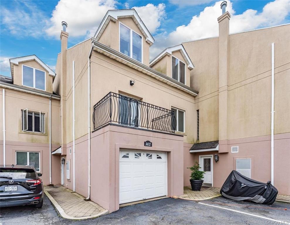 View of front of house with a garage and a balcony