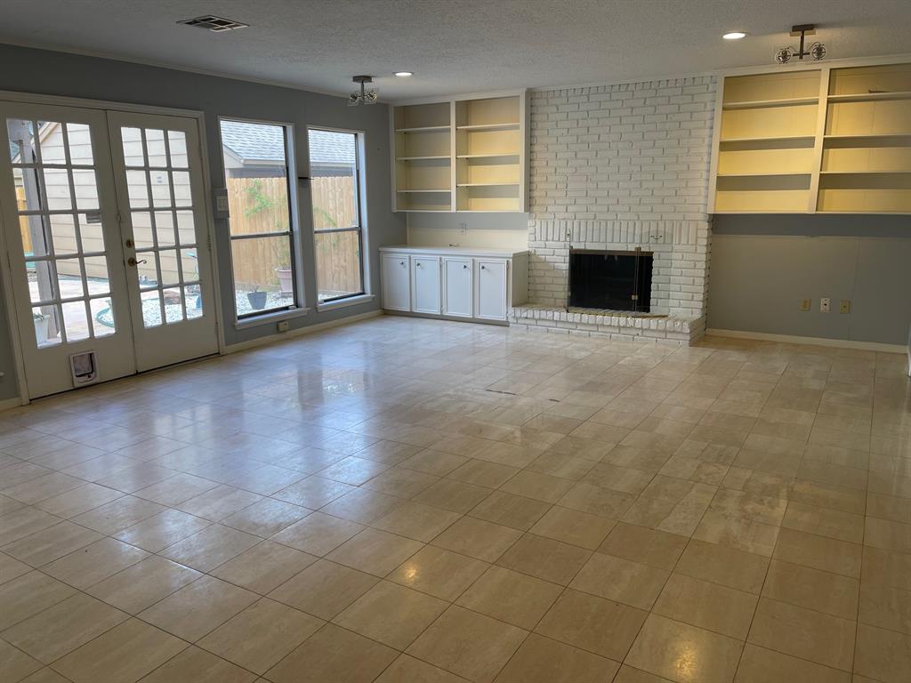 This huge den boasts an entire wall of windows and French doors looking into the fenced backyard.  The French doors open directly onto the covered back porch.