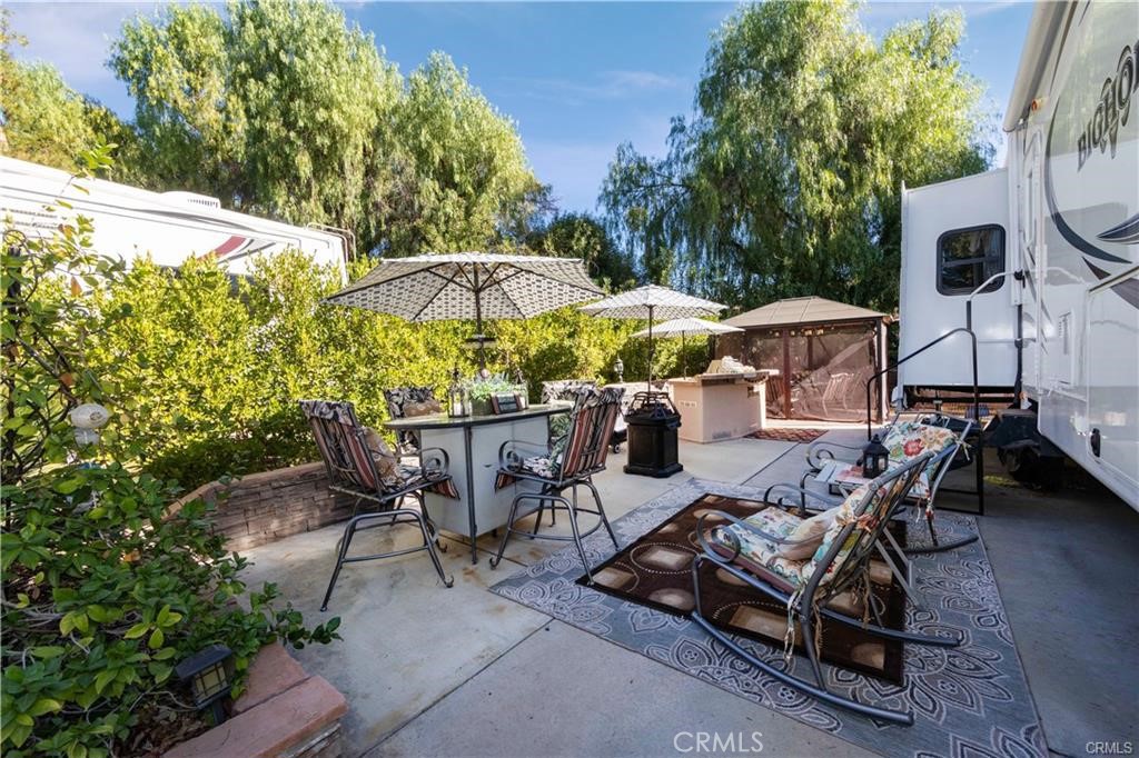 a view of a patio with chairs and table under an umbrella