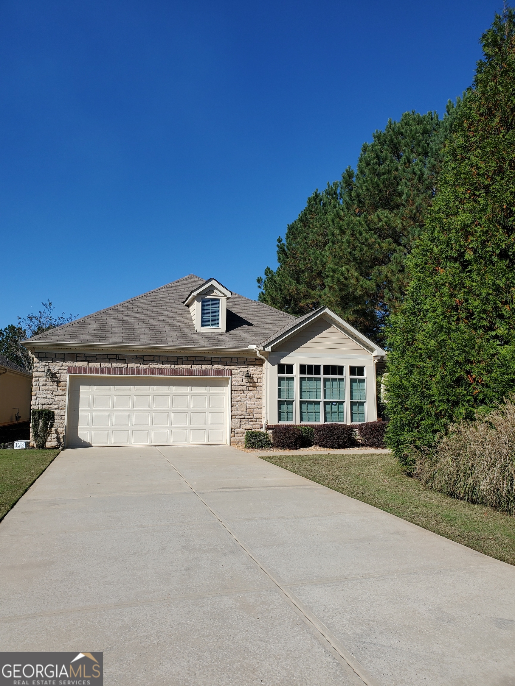 a front view of a house with a garden