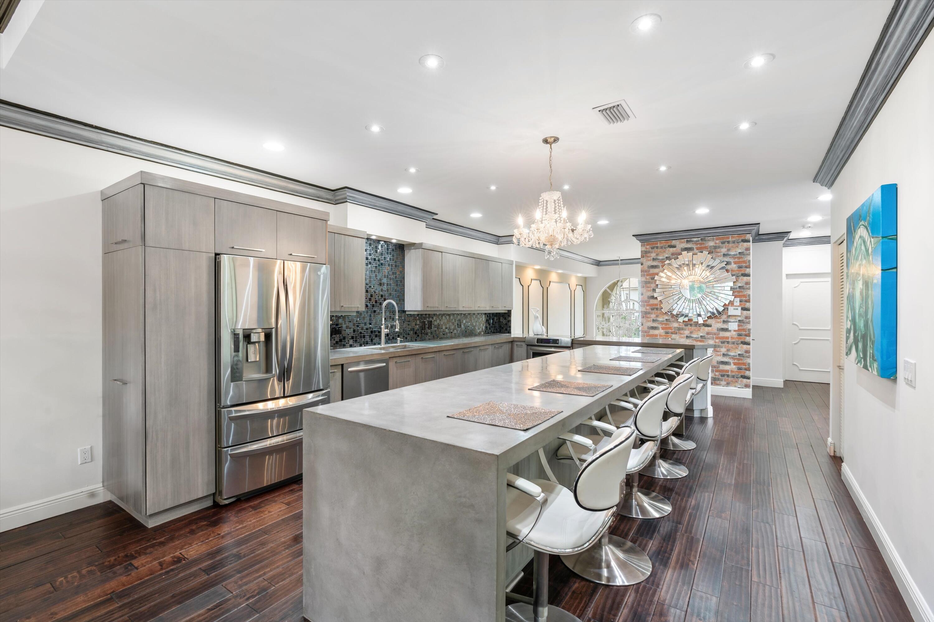 a kitchen with stainless steel appliances a dining table chairs and wooden floor