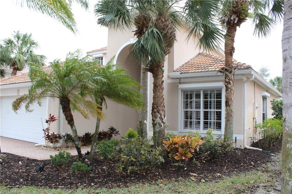 a view of a house with a yard and potted plants