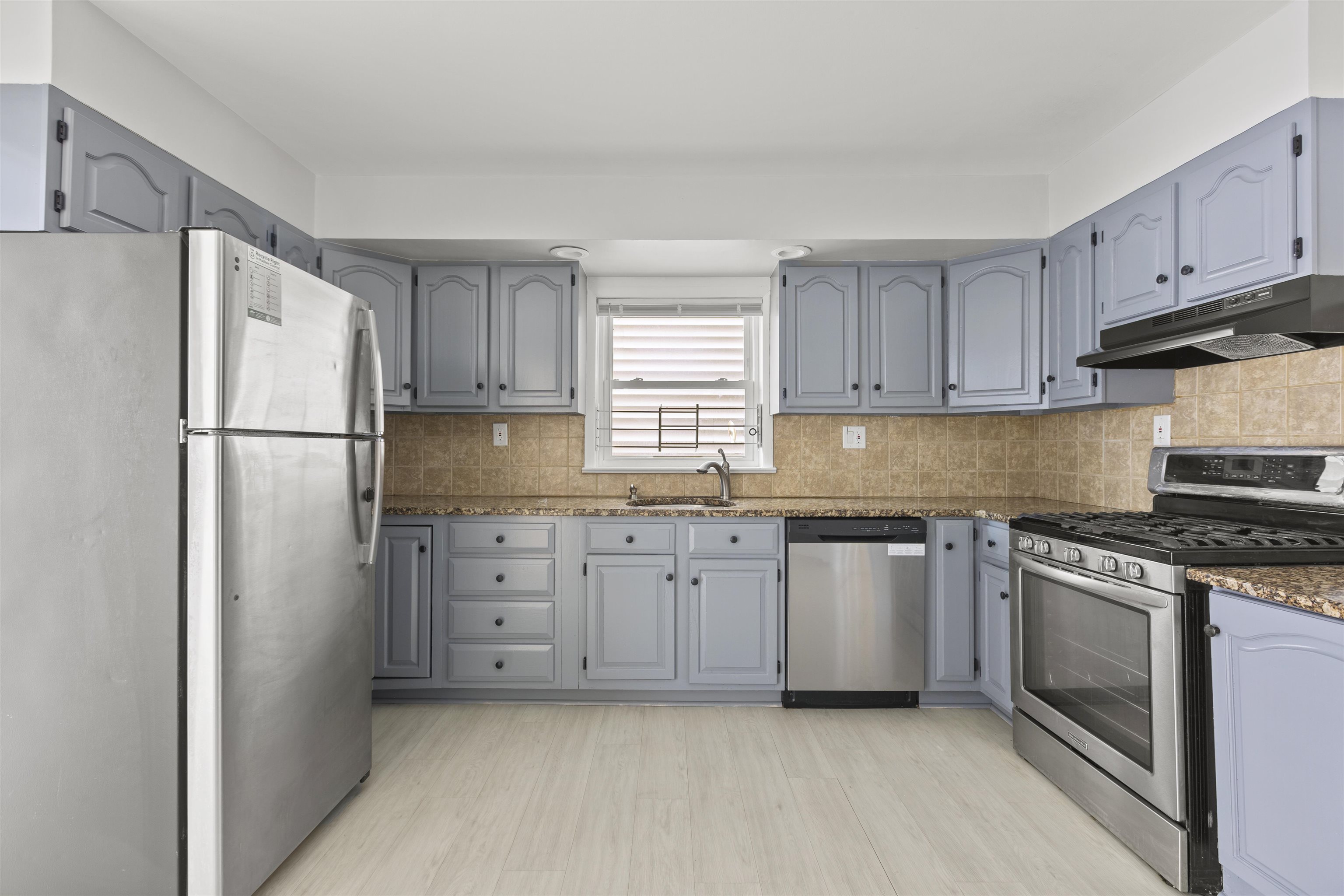 a kitchen with granite countertop cabinets appliances and a window