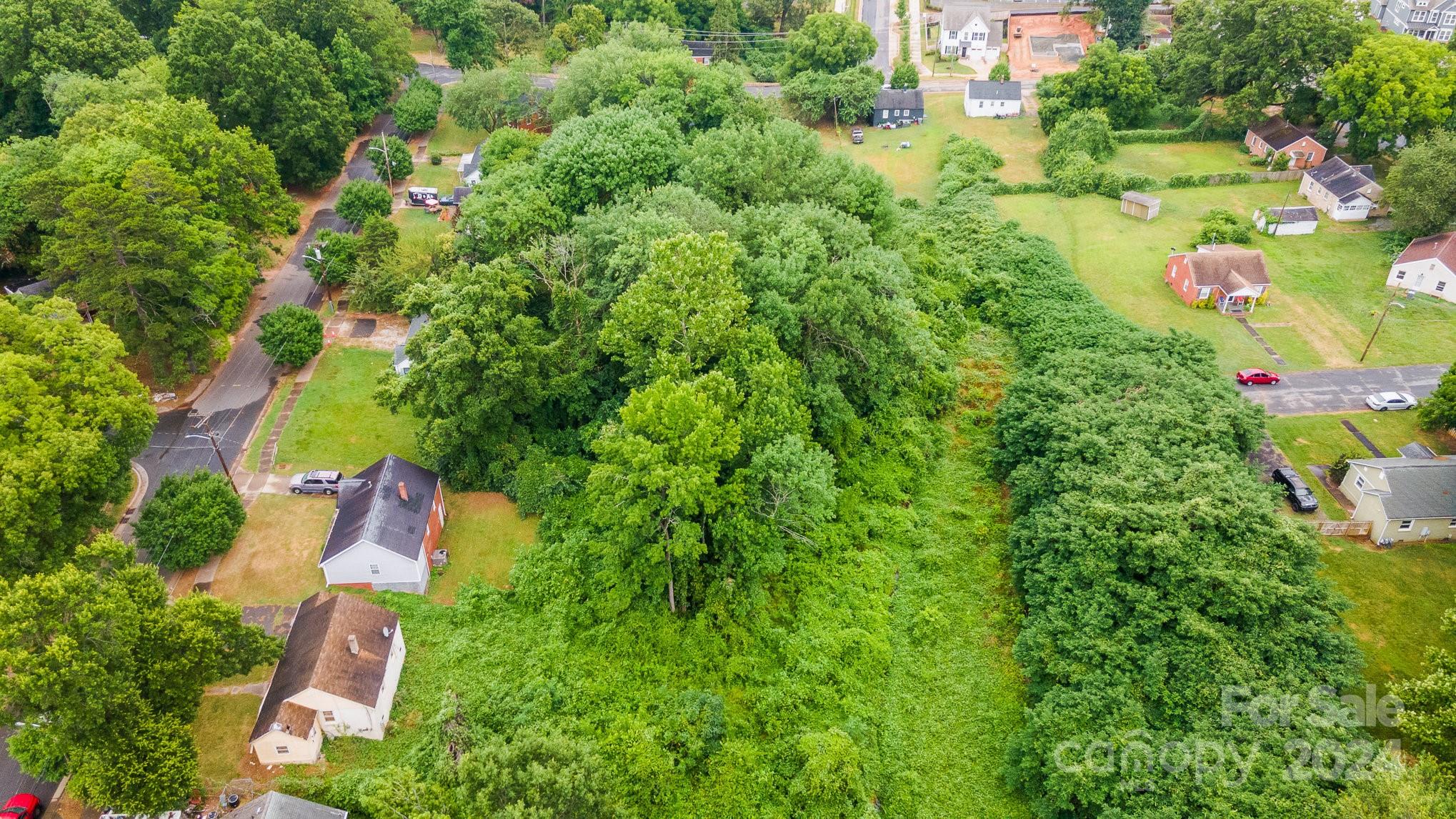 an aerial view of residential house with outdoor space and trees all around