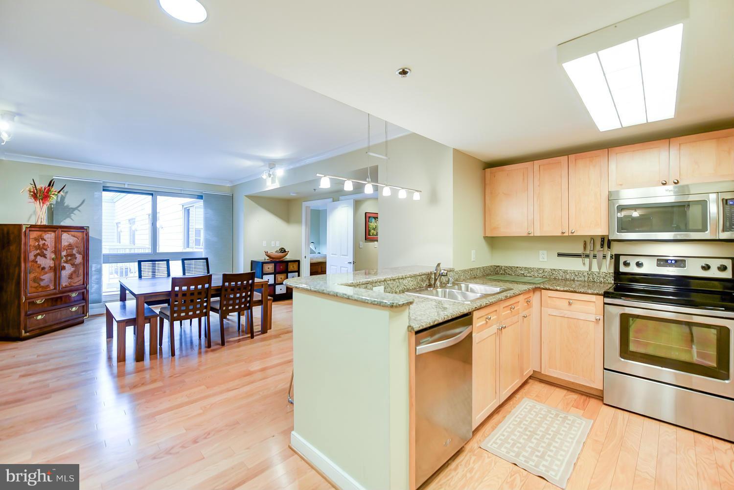 a kitchen with lots of white cabinets appliances and furniture