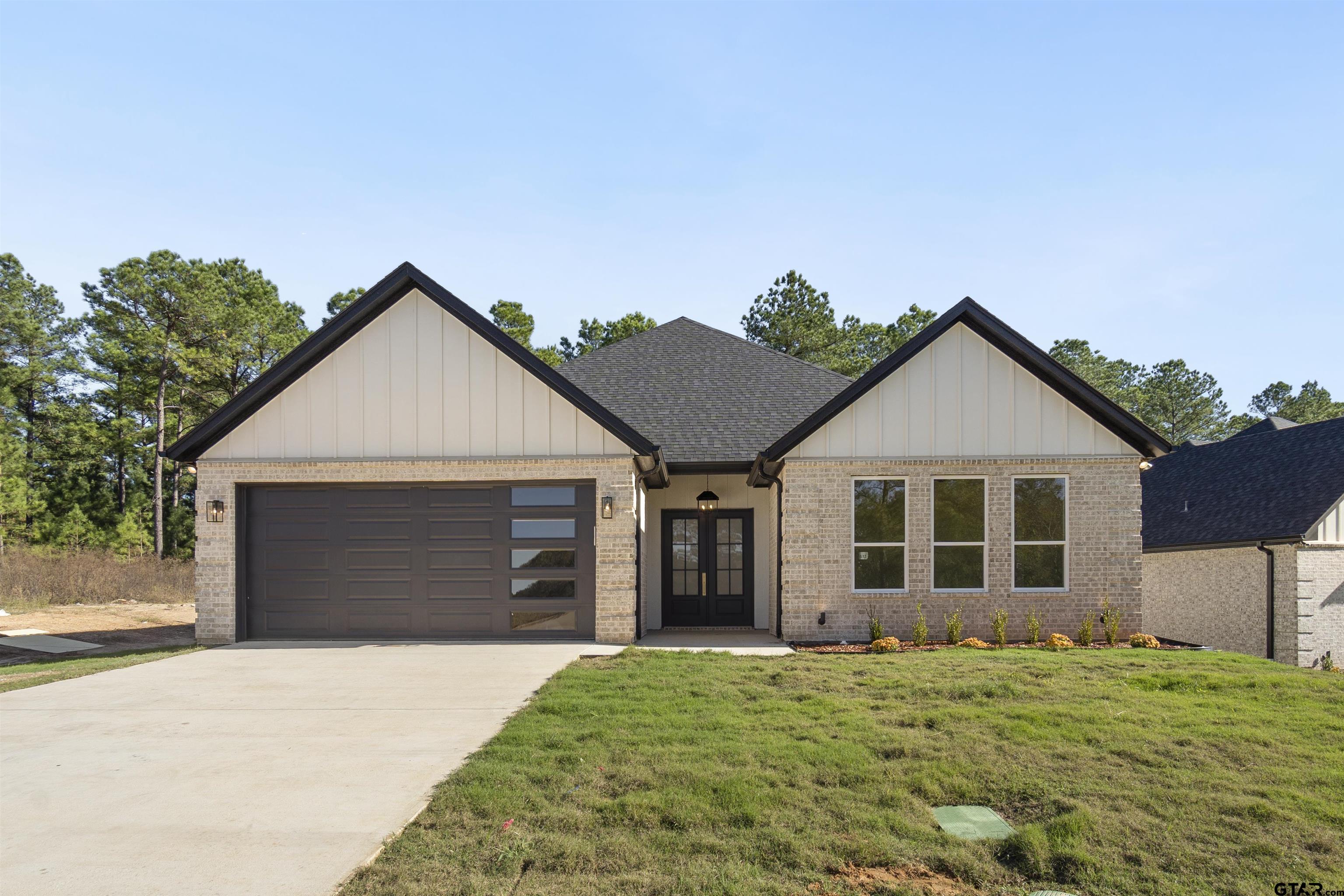 a front view of a house with a yard and garage