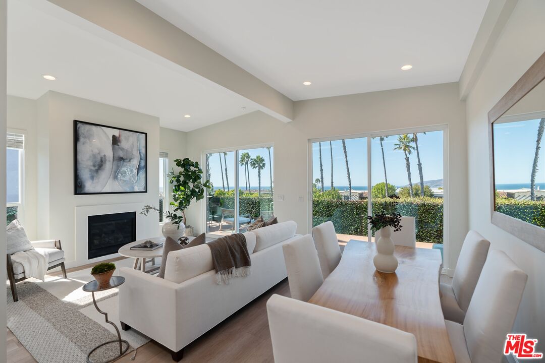 a living room with furniture fireplace and a large window