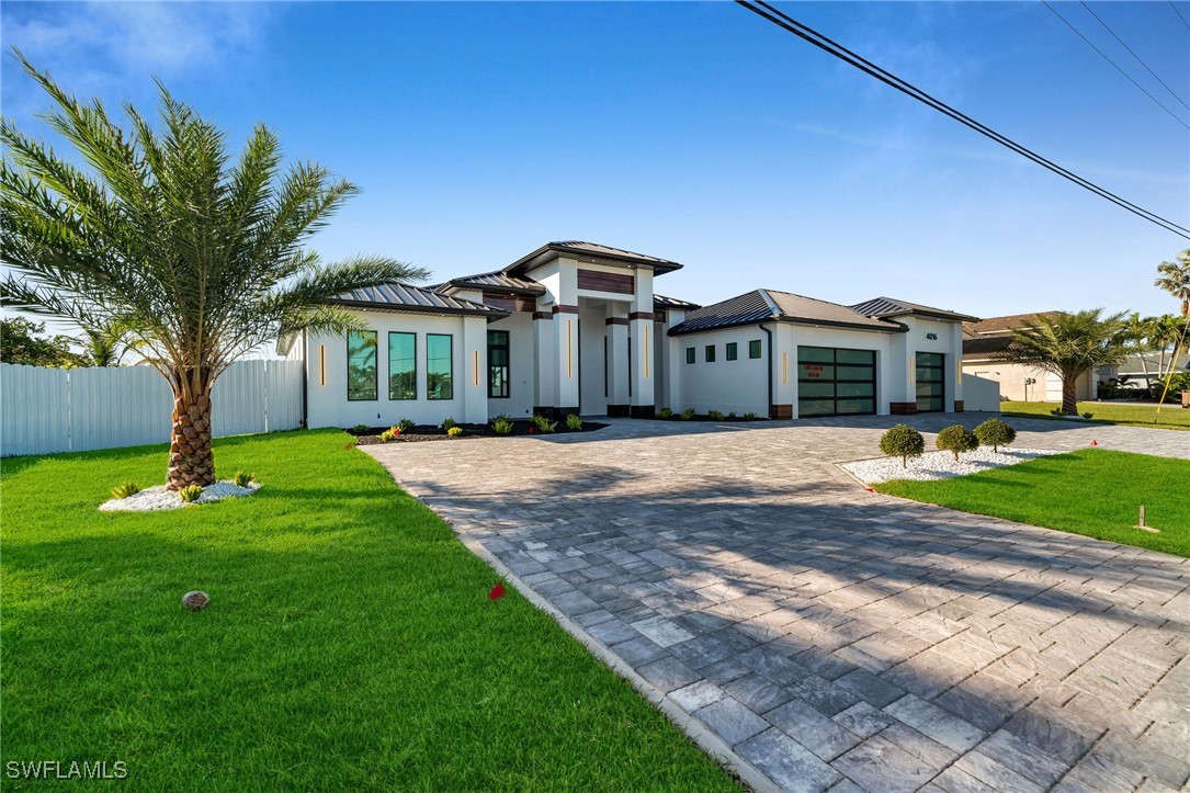 a front view of a house with a yard and trees