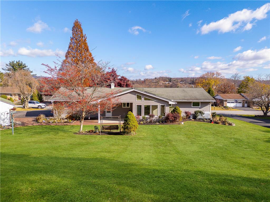 a view of a house with a big yard and large trees