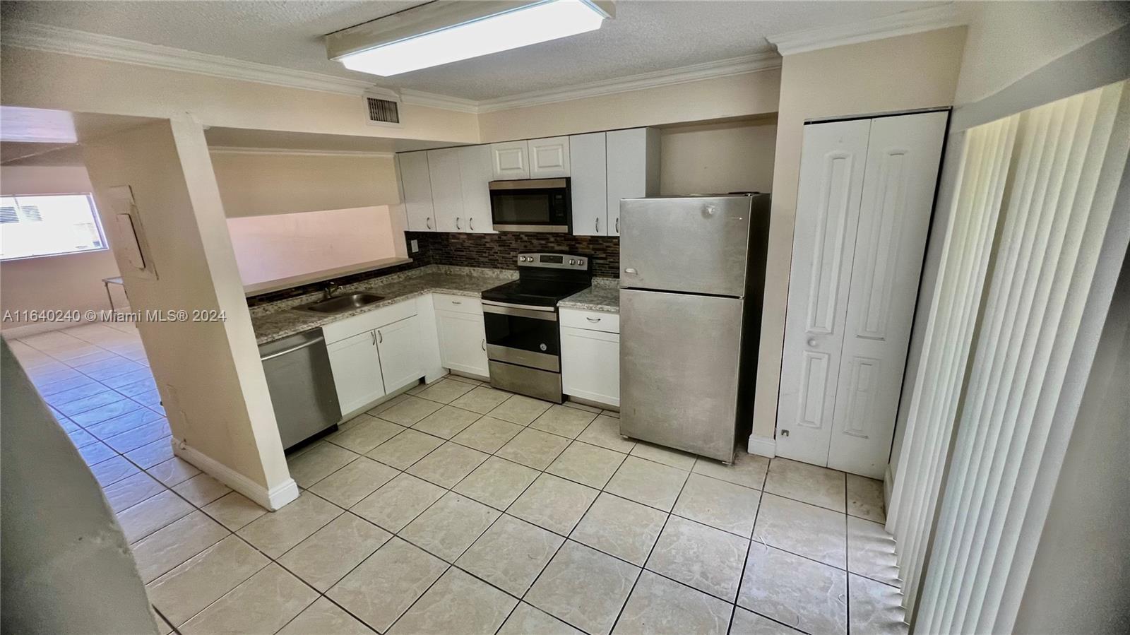 a kitchen with a refrigerator stove and sink