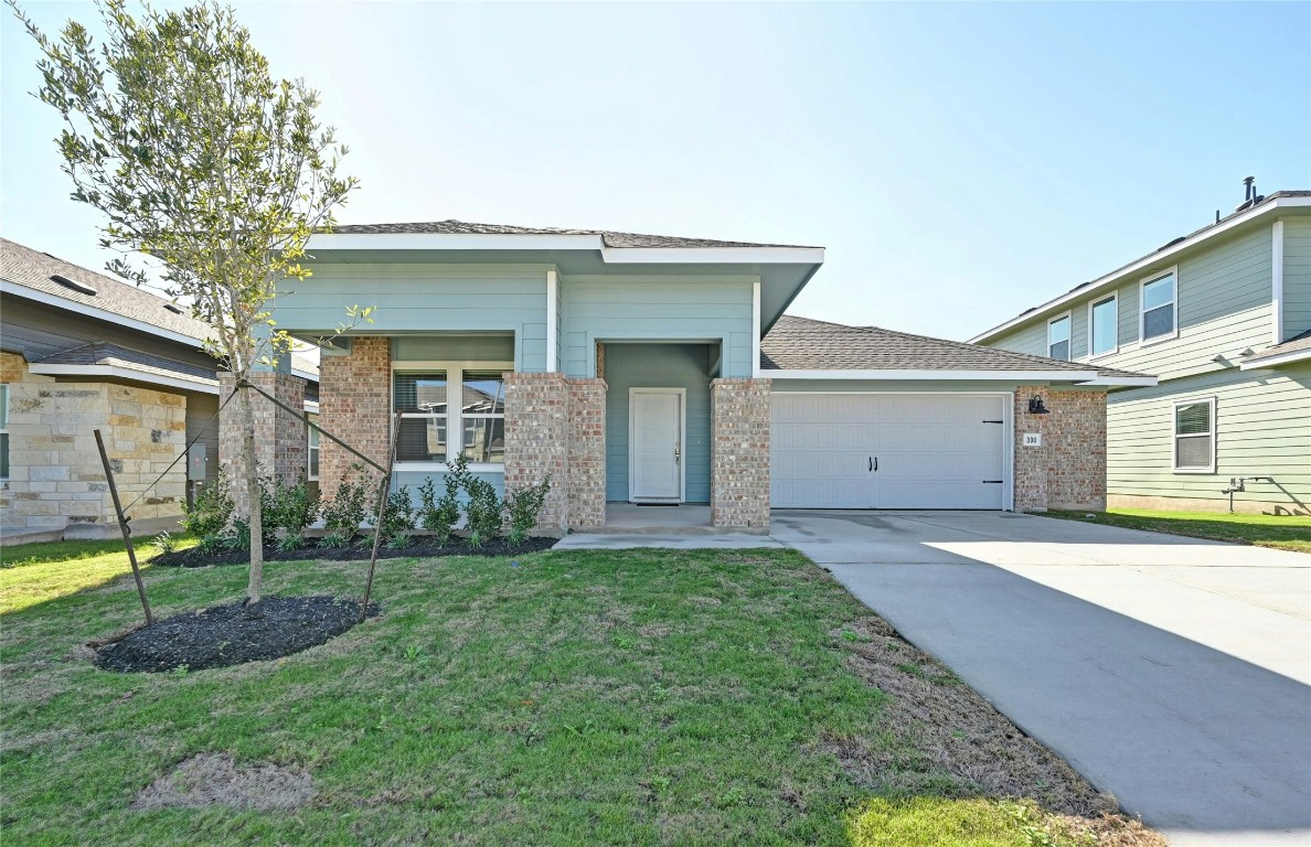 a front view of a house with a yard and garage