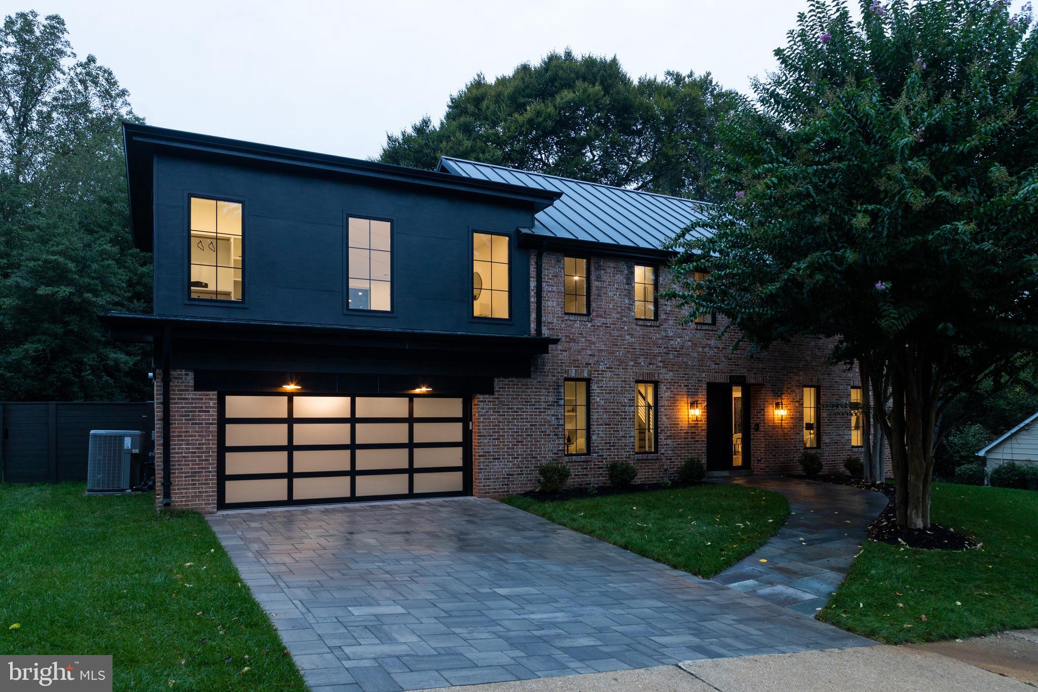 a front view of a house with a garden and trees