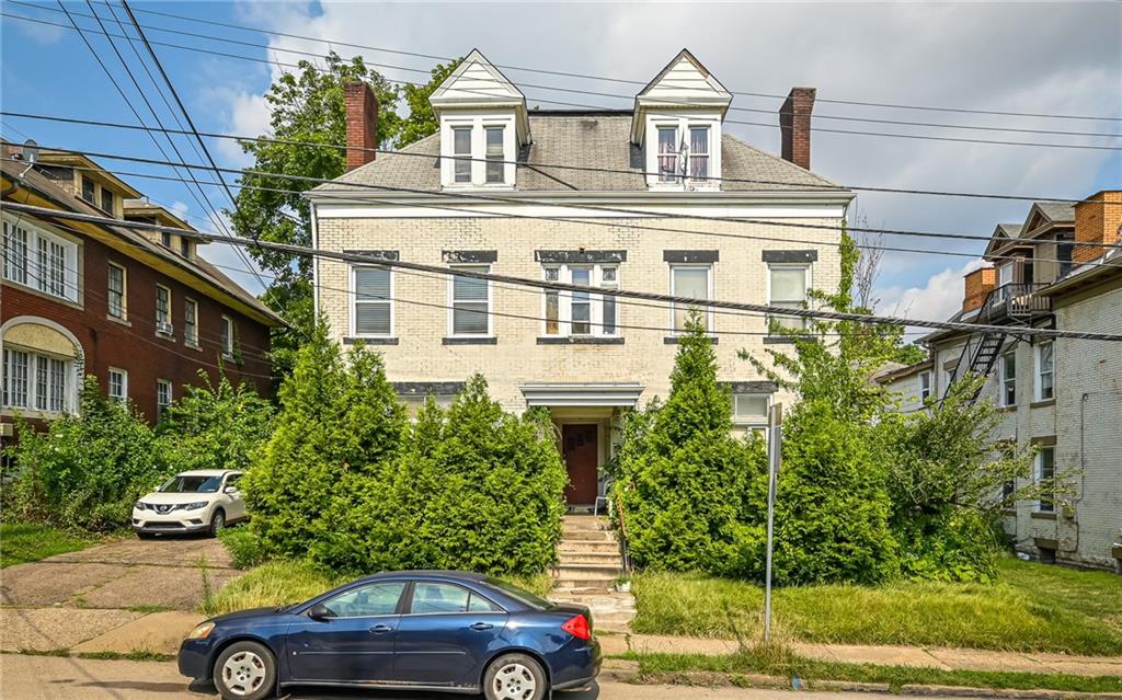 a front view of a house with a garden