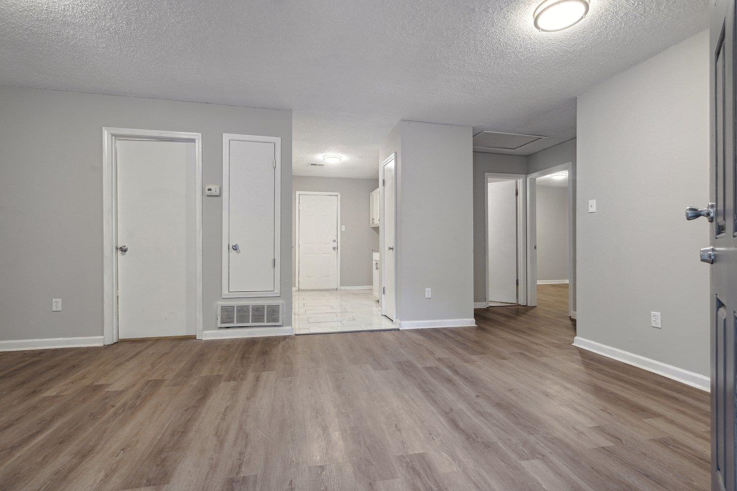 Interior space featuring light wood-type flooring and a textured ceiling