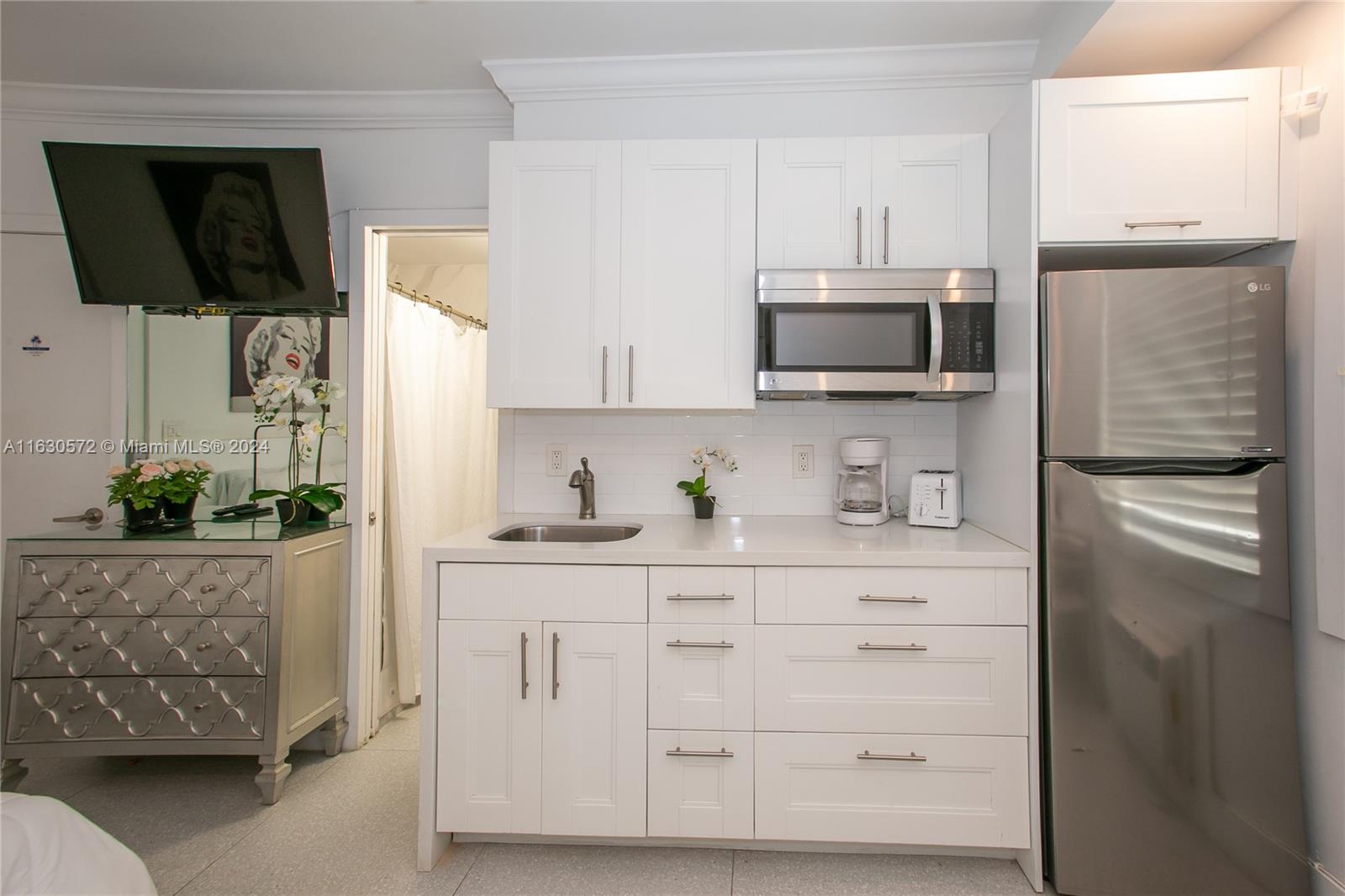 a kitchen with white cabinets and stainless steel appliances