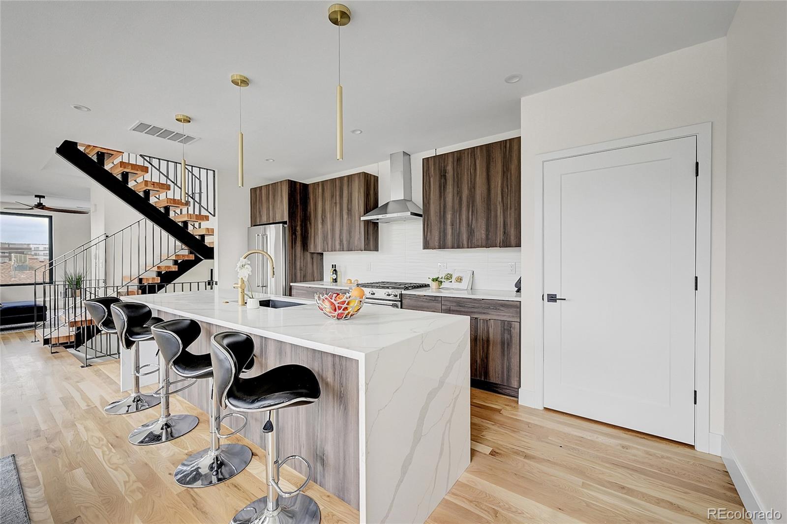 a kitchen with stainless steel appliances kitchen island a stove a sink and a refrigerator