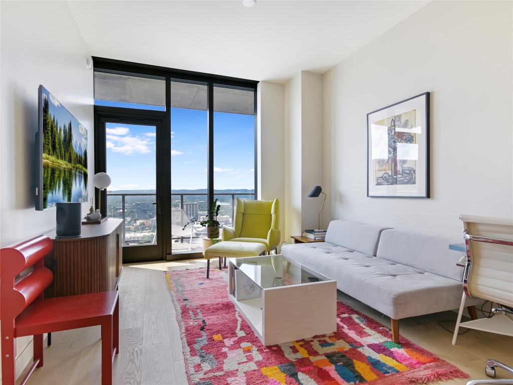 a living room with furniture large window and a table