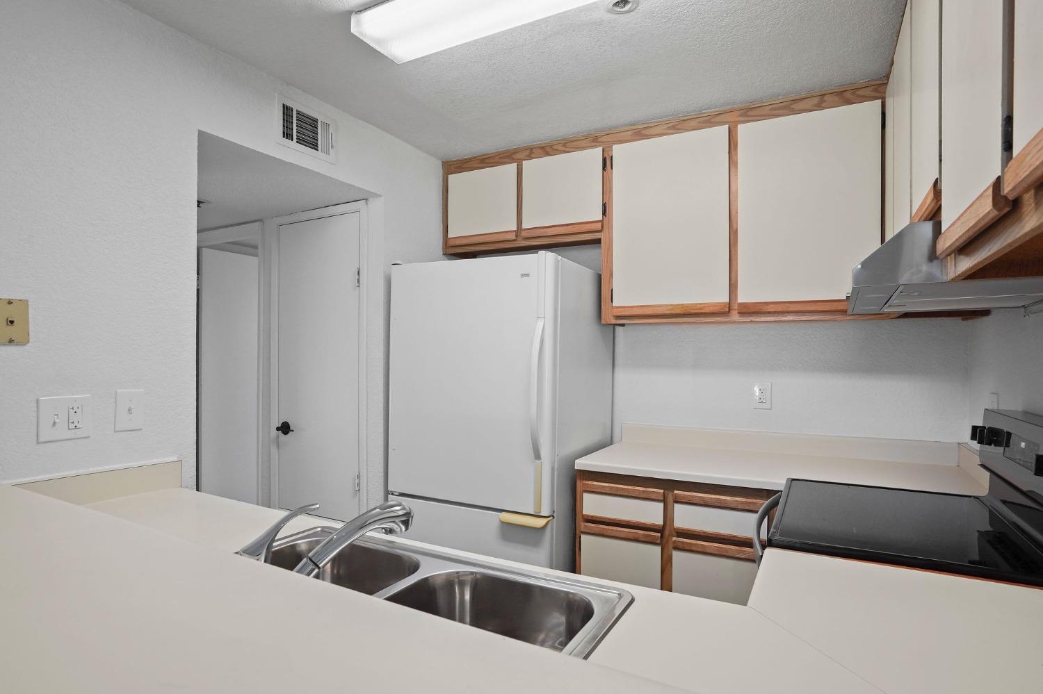 a kitchen with a refrigerator sink and cabinets