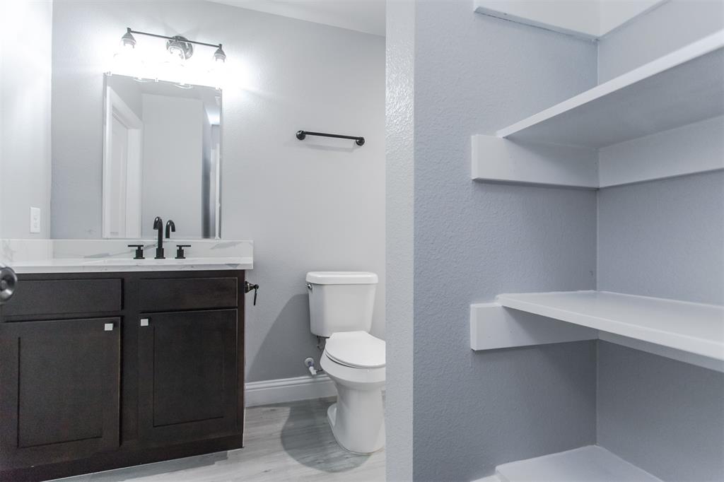 a bathroom with a sink a toilet a light fixture and mirror