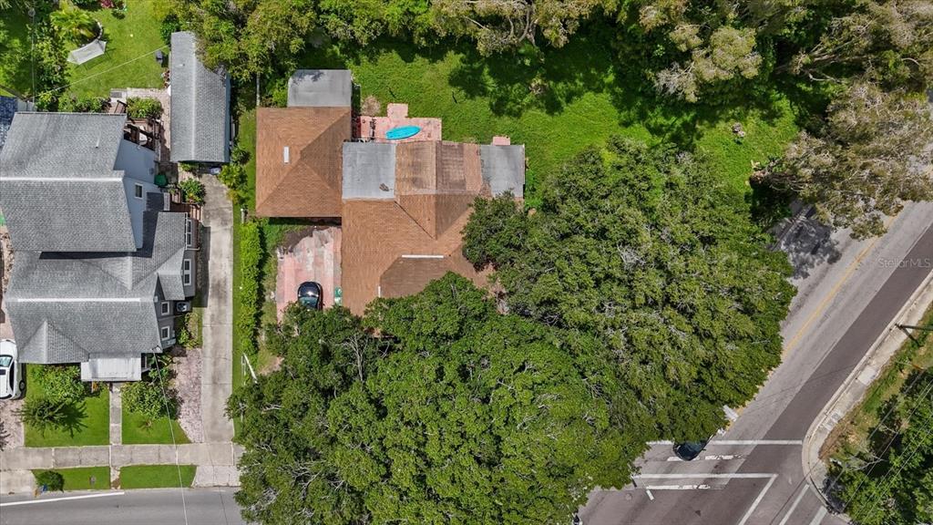 an aerial view of residential house with outdoor space and trees all around