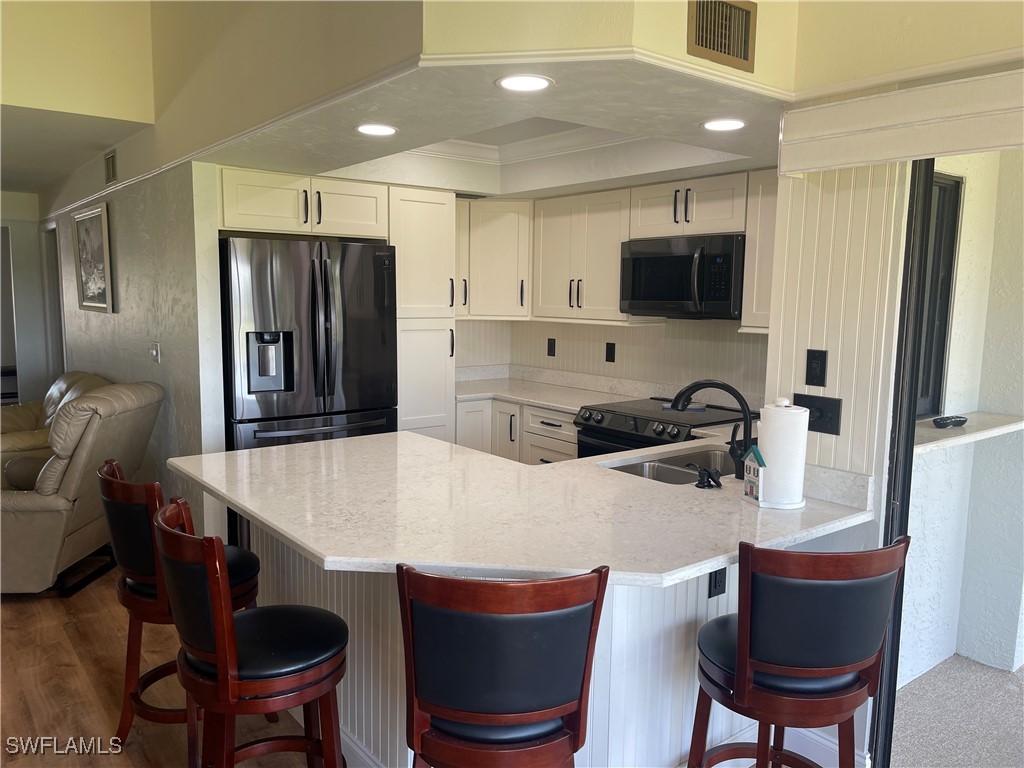 a kitchen with stainless steel appliances kitchen island granite countertop a dining table and chairs