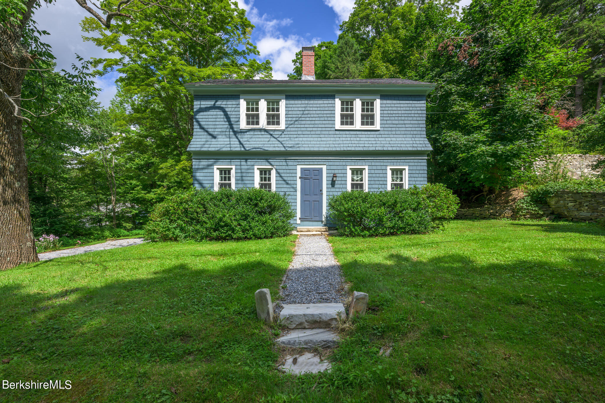 a front view of a house with a garden