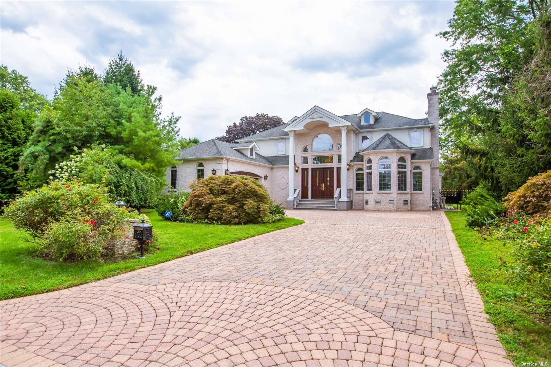 a front view of a house with a yard and trees