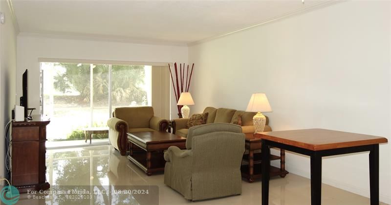 a living room with furniture and a floor to ceiling window