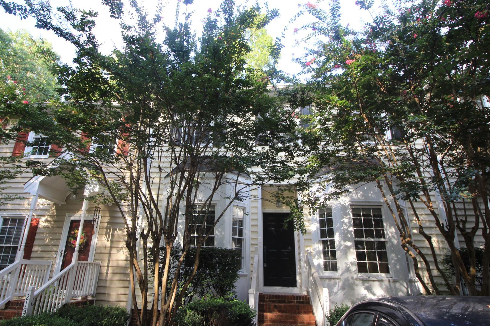 a front view of a house with a tree