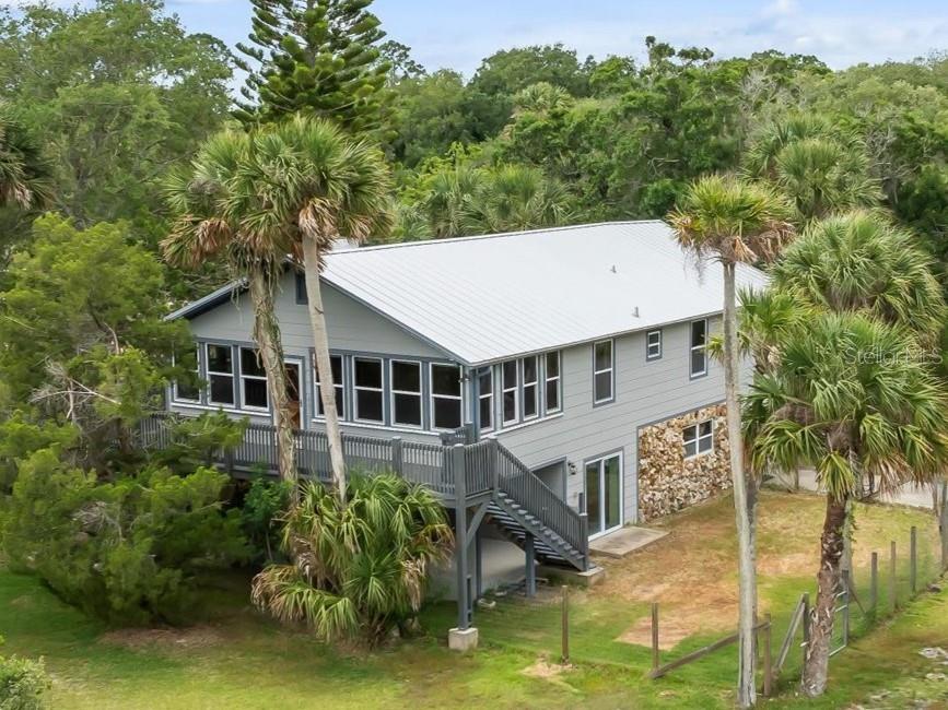 an aerial view of a house with swimming pool and next to a yard