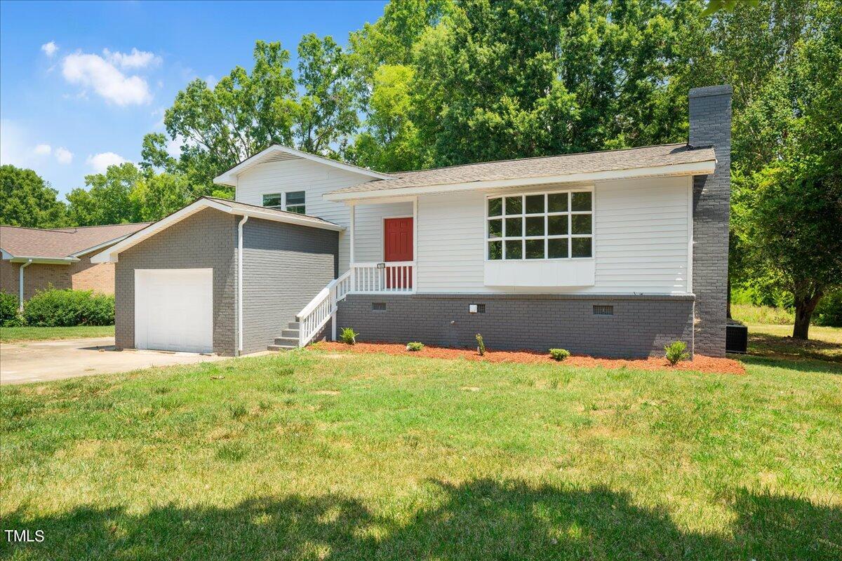 a view of a house with a yard and garage