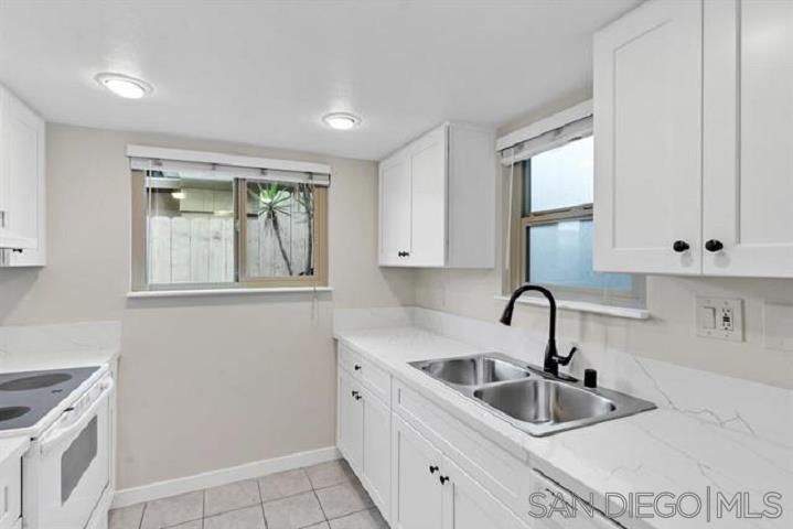 a kitchen with sink a refrigerator and cabinets