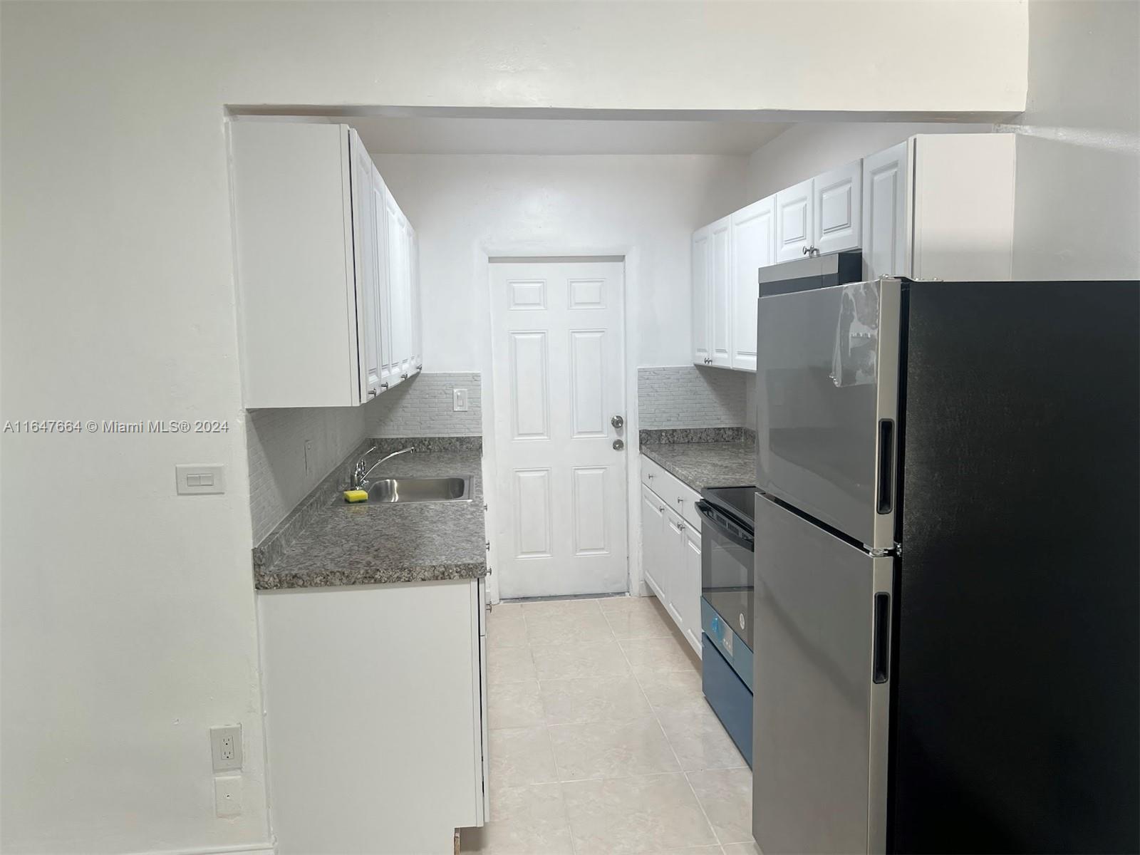 a kitchen with stainless steel appliances granite countertop a refrigerator and a stove