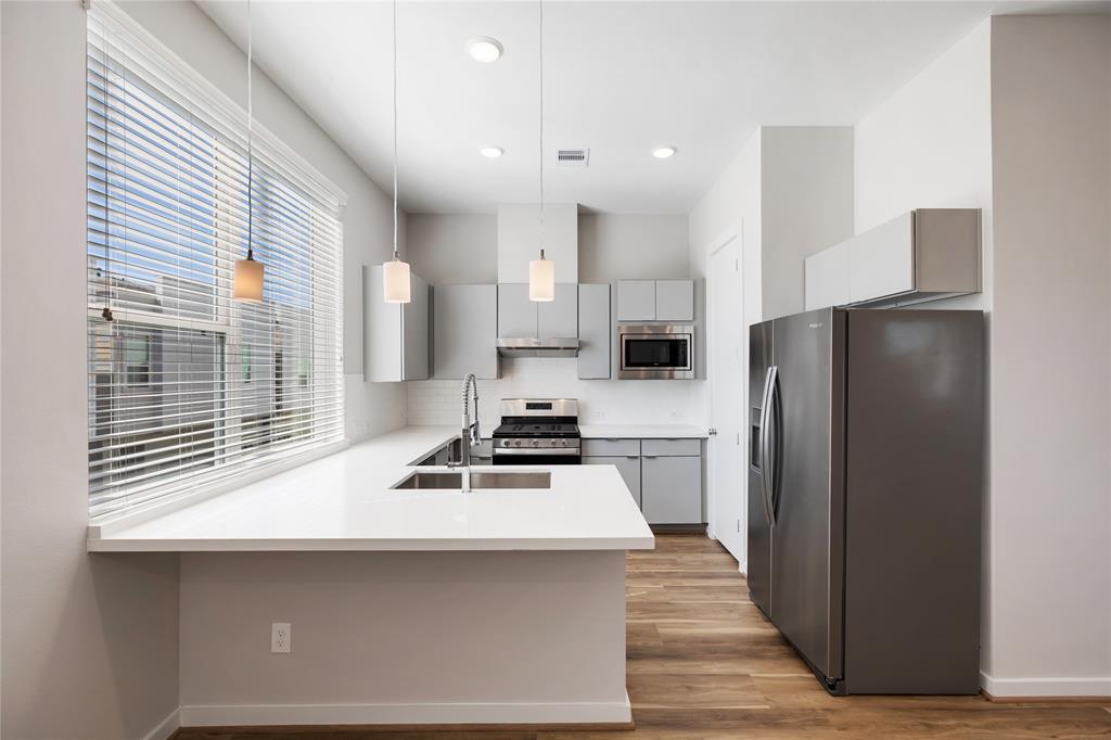 a kitchen with a refrigerator a stove and a sink