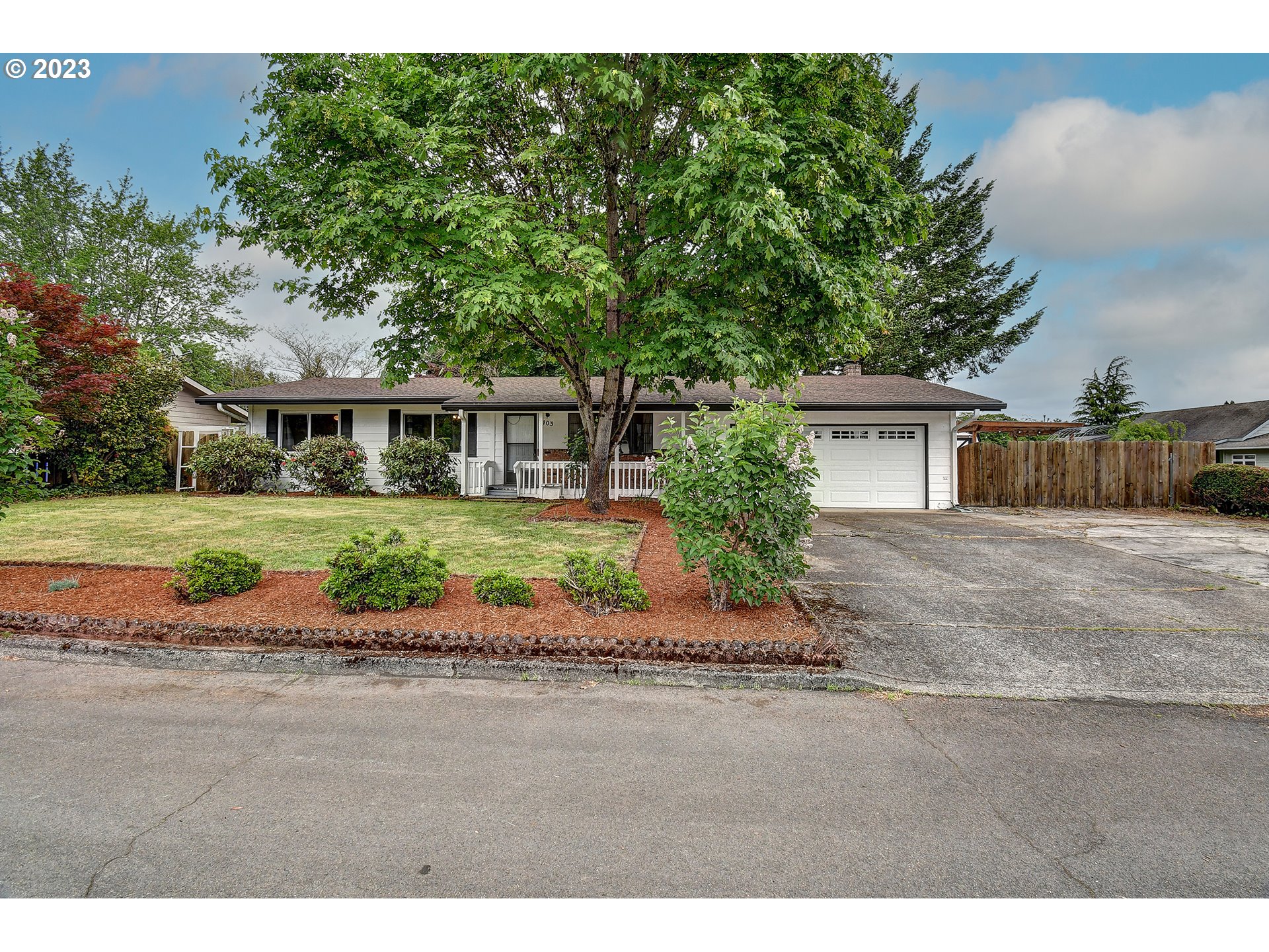 a front view of a house with a yard and potted plants