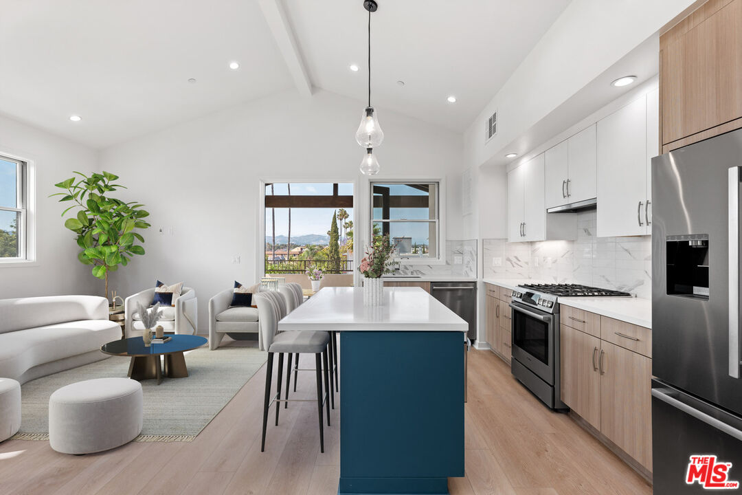 a kitchen with stainless steel appliances granite countertop a sink a stove and a refrigerator