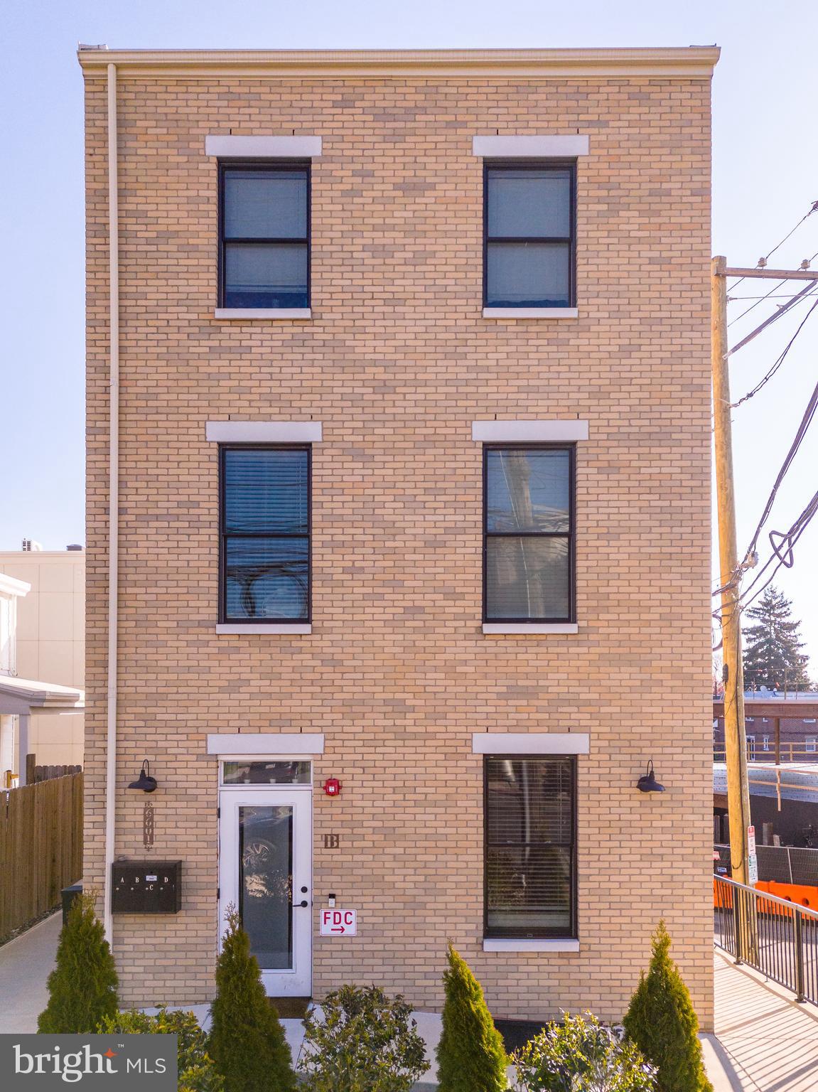 a brick house with four windows and a yard