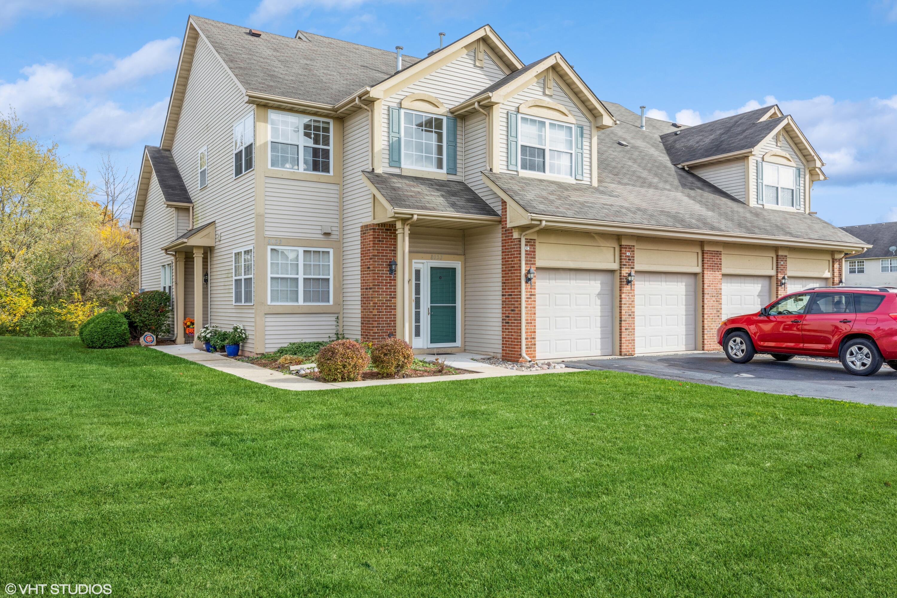 a front view of a house with a yard and garage