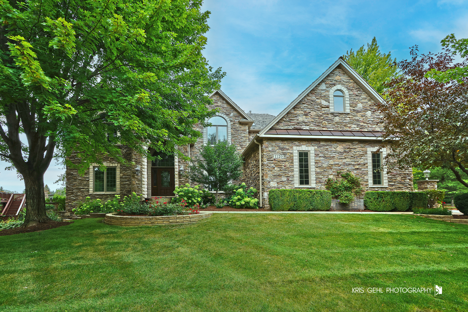 a front view of a house with a garden and yard