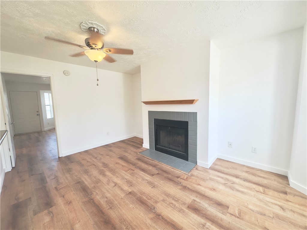 Living room featuring ceiling fan, wood-style floo