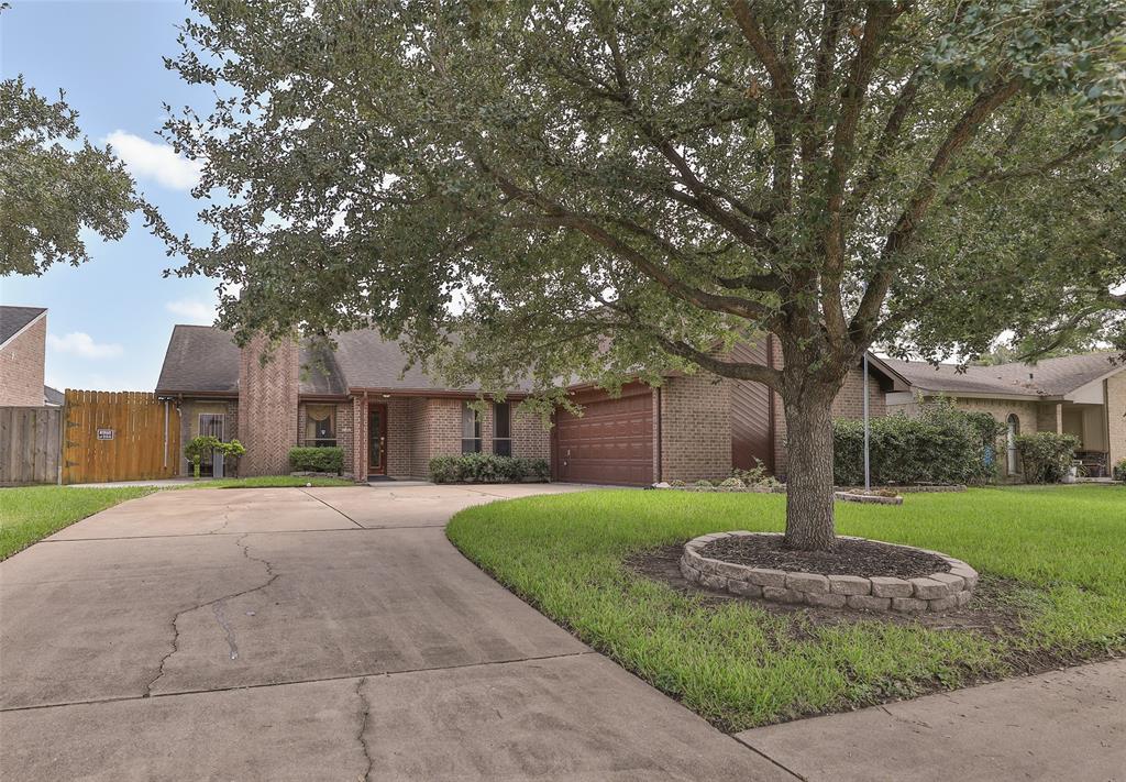 a front view of a house with a yard and tree