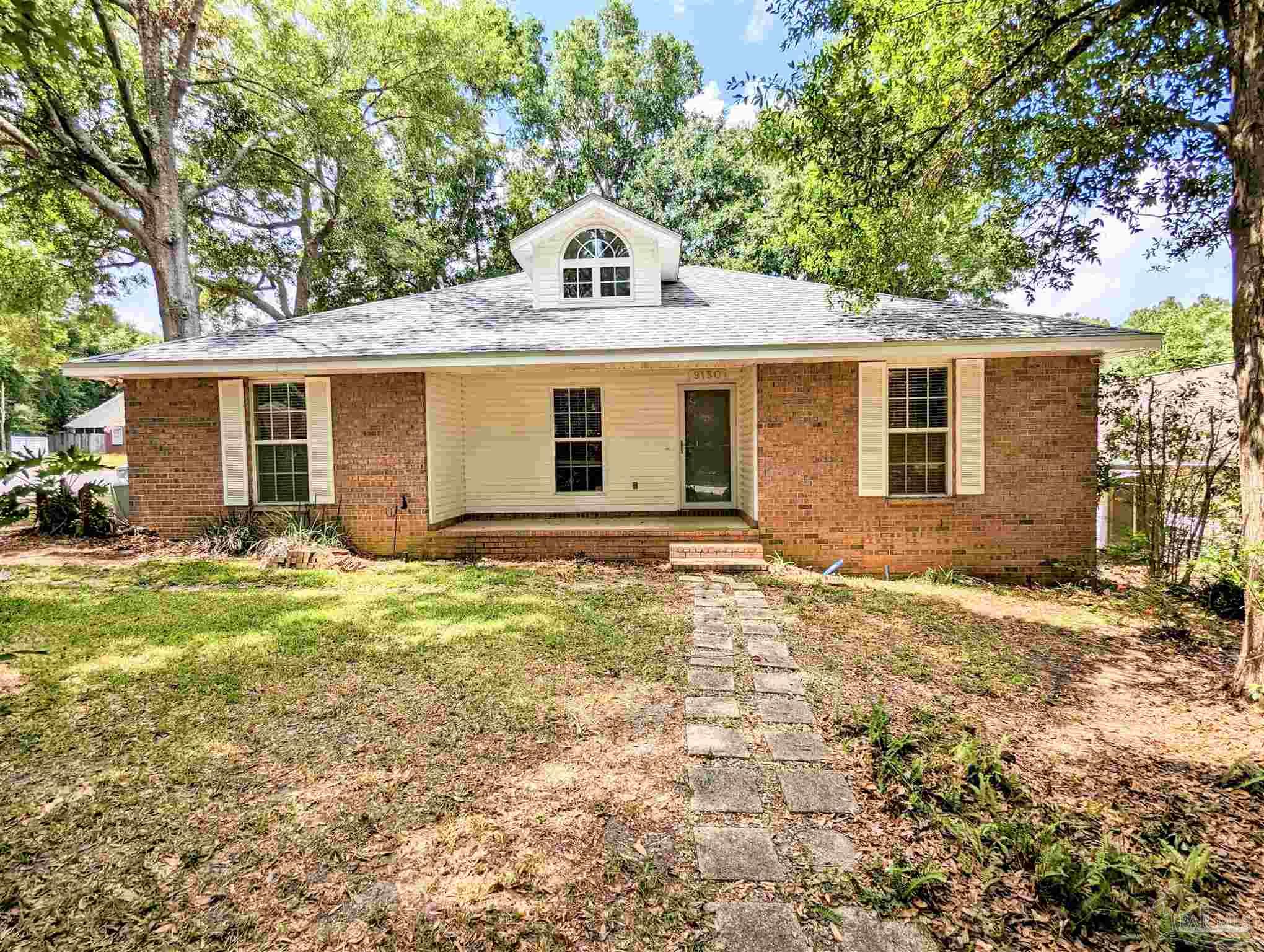 a front view of house with yard and trees around